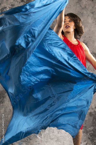 Female dancer in a turn with dark blue fabric.
