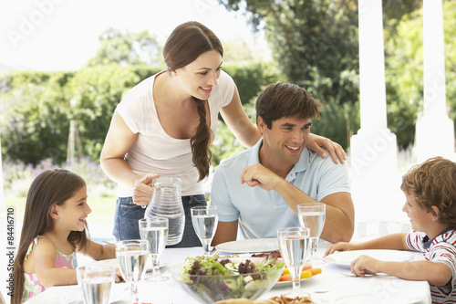 Family Enjoying Outdoor Meal In Garden Together