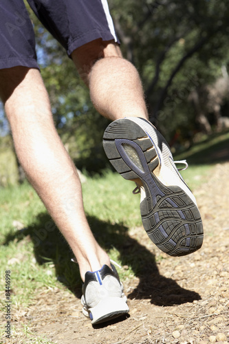 Close Up Of Man s Feet Jogging Along Woodland Path