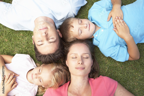 Overhead View Of Family Resting On Grass