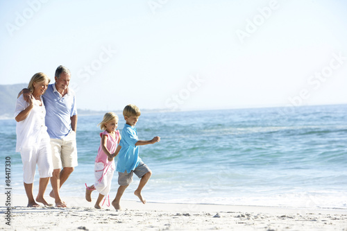 Grandparents and Grandchildren Walking Along Beach