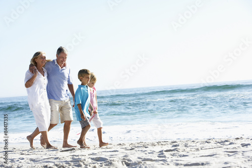 Grandparents and Grandchildren Walking Along Beach © Monkey Business
