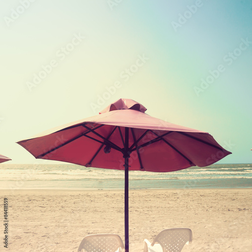 Retro beach with pink umbrellas © Andreka Photography