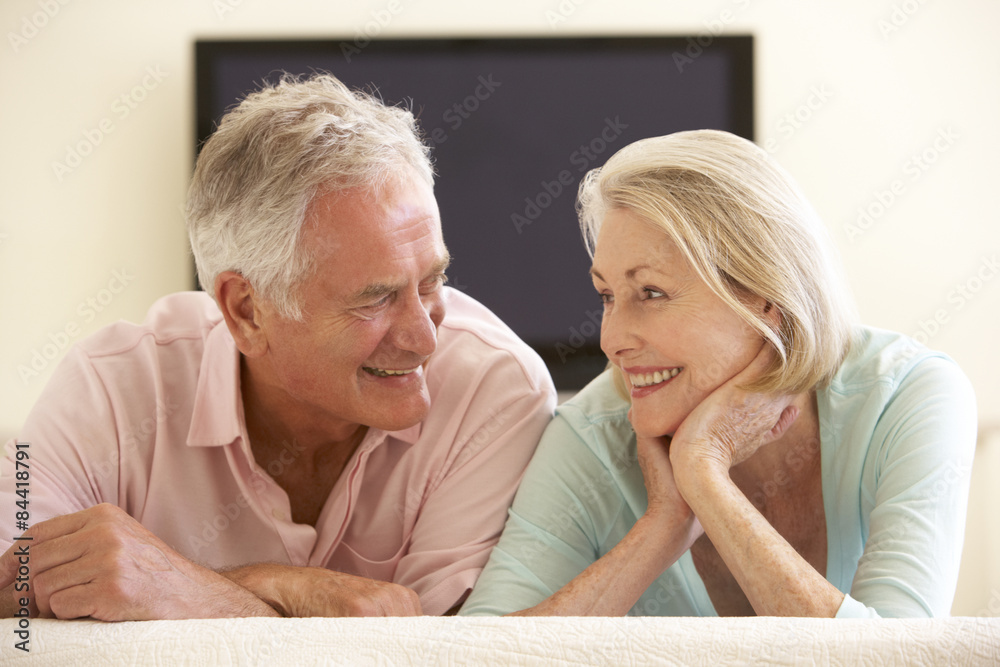 Senior Couple Watching Widescreen TV At Home Senior Couple Watching Widescreen TV At Home