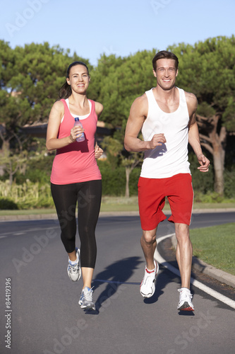 Young Couple Running On Road
