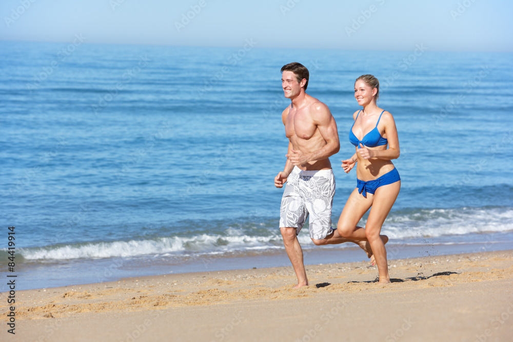 Young Couple Running Along Summer Beach Young Couple Running Along Summer Beach