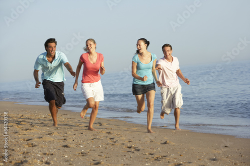 Group Of Friends Running Along Beach