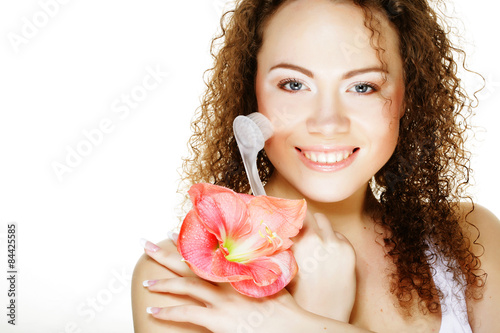Beautiful spa girl holding pink flower and brush