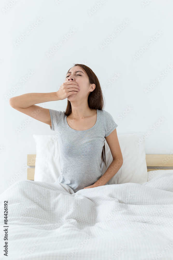 Young lady wake up and yawning on bed Young lady wake up and yawning on bed