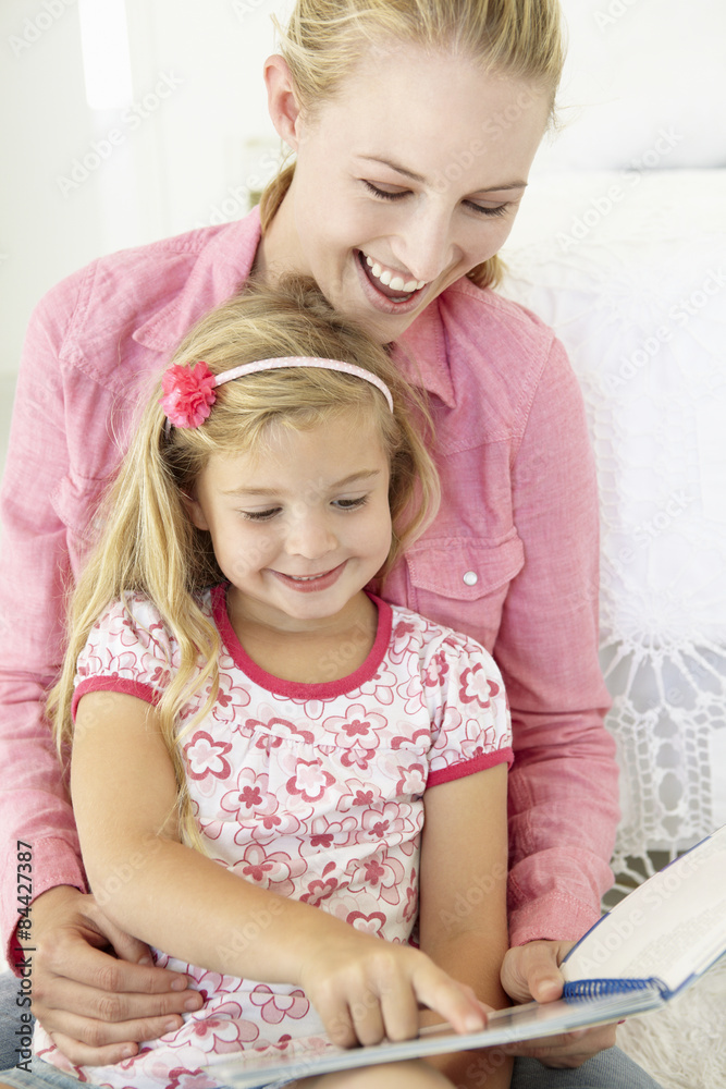 Mother And Daughter Reading Book In Bedroom Mother And Daughter Reading Book In Bedroom