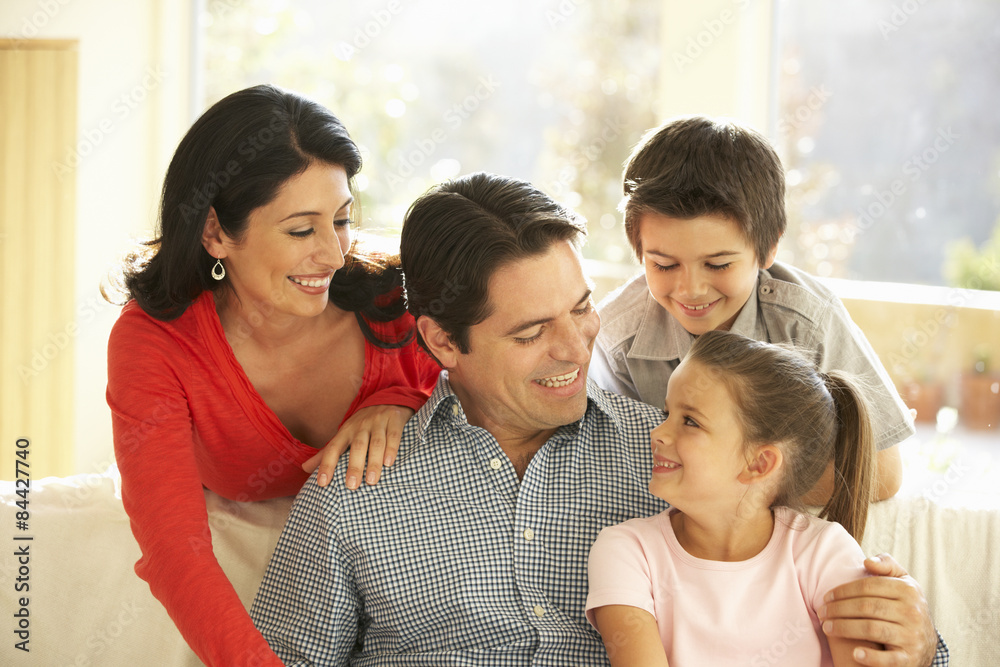 Obraz premium Young Hispanic Family Relaxing On Sofa At Home