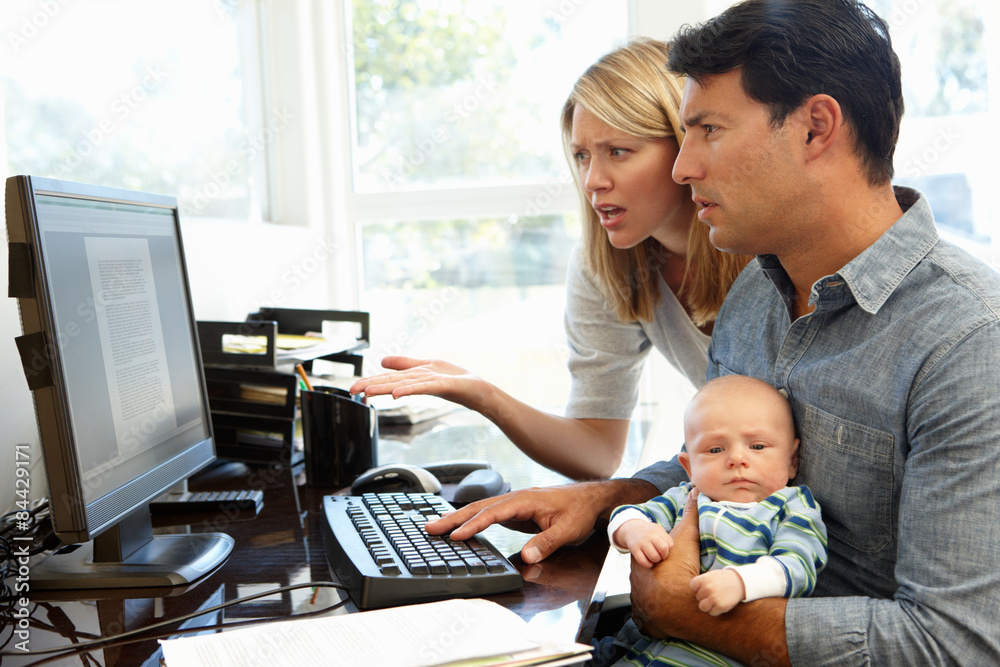 Couple working in home office with baby Couple working in home office with baby