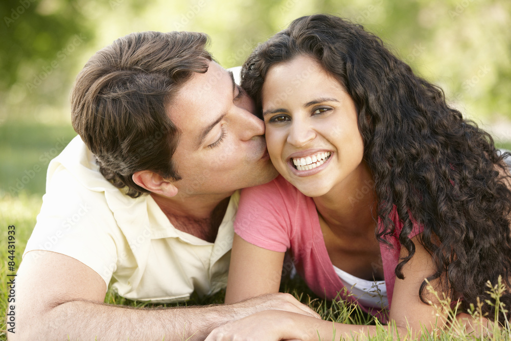 Romantic Young Hispanic Couple Relaxing In Park