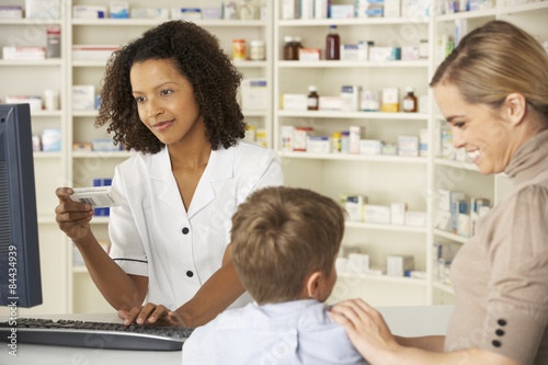 Pharmacist in pharmacy with mother and child