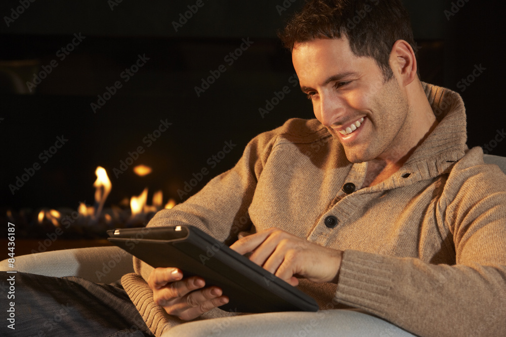 Man using tablet in front of fire at home Man using tablet in front of fire at home