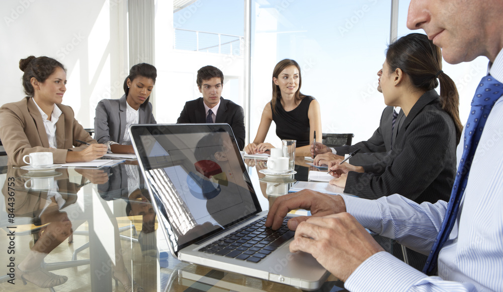 Close Up Of Businessman Using Laptop During Board Meeting Around Glass Table Close Up Of Businessman Using Laptop During Board Meeting Around Glass Table