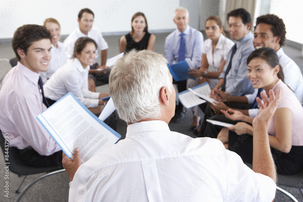 Businesspeople Seated In Circle At Company Seminar Businesspeople Seated In Circle At Company Seminar