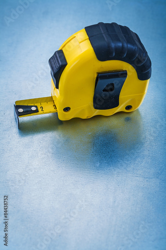 Yellow plastic tape measure on metallic background construction 