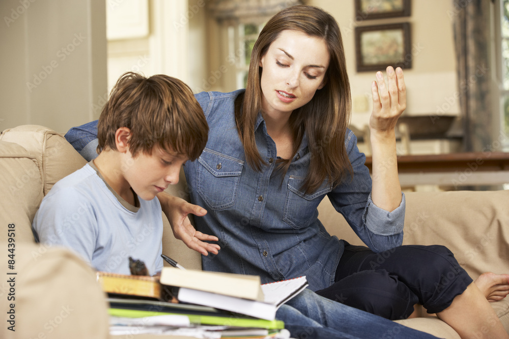 Mother Becoming Frustrated With Son Whilst Doing Homework Sitting On Sofa At Home Mother Becoming Frustrated With Son Whilst Doing Homework Sitting On Sofa At Home