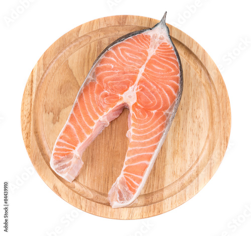 Raw salmon steak on cutting board.