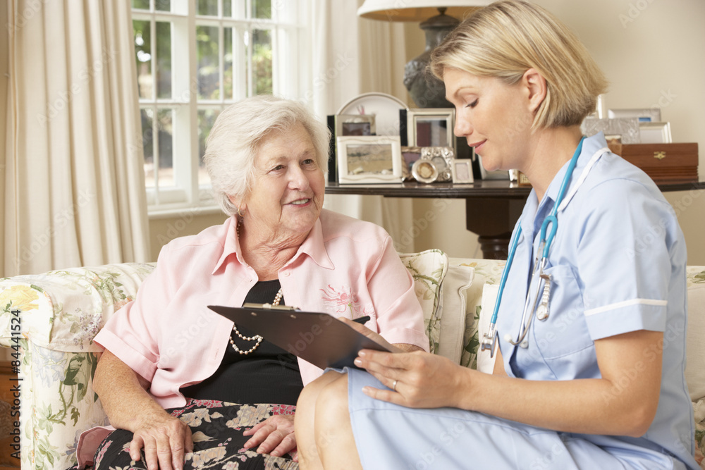 Fototapeta premium Retired Senior Woman Having Health Check With Nurse At Home