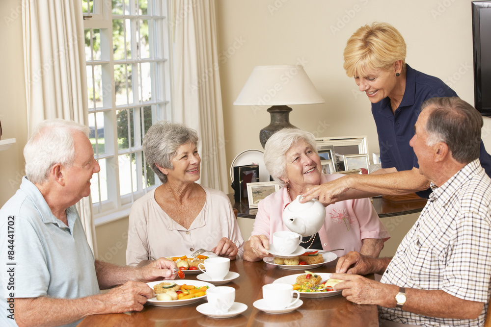 Group Of Senior Couples Enjoying Meal Together In Care Home With Home Help Group Of Senior Couples Enjoying Meal Together In Care Home With Home Help