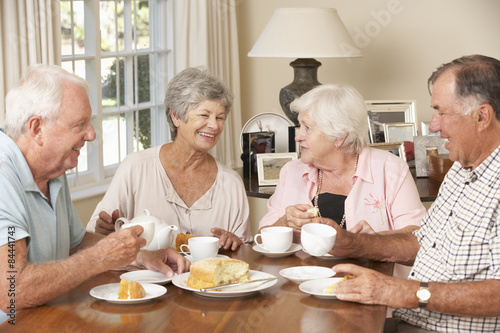 Group Of Senior Couples Enjoying Afternoon Tea Together At Home