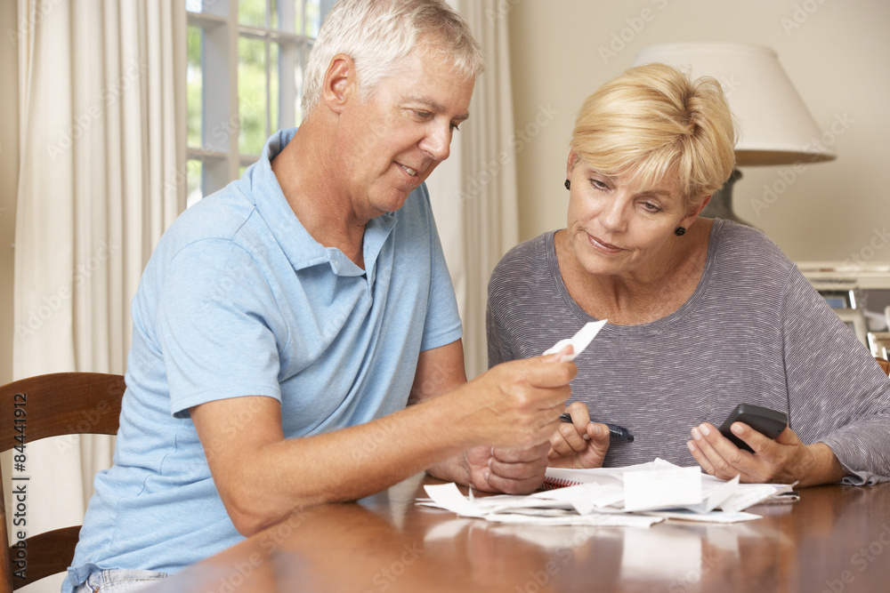 Mature Couple Checking Finances And Going Through Bills Together Mature Couple Checking Finances And Going Through Bills Together