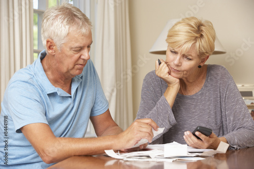 Worried Mature Couple Checking Finances And Going Through Bills Together