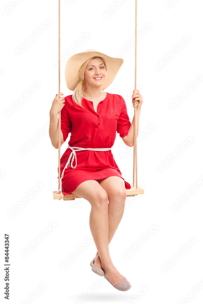 Woman with a stylish hat swinging on a swing Woman with a stylish hat swinging on a swing