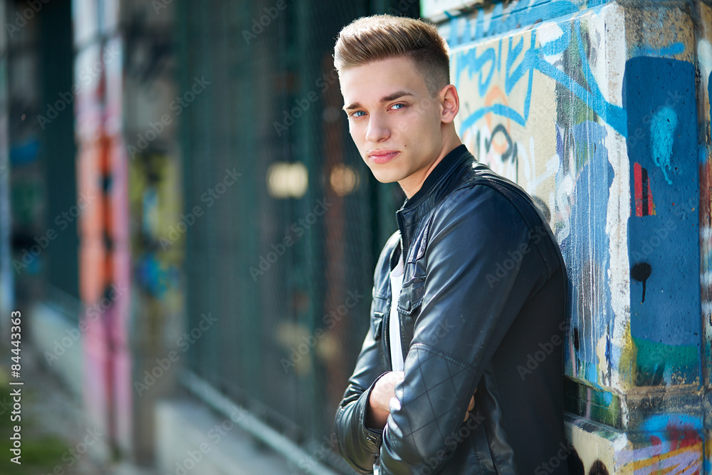 Young boy leaning against a graffity wall Young boy leaning against a graffity wall