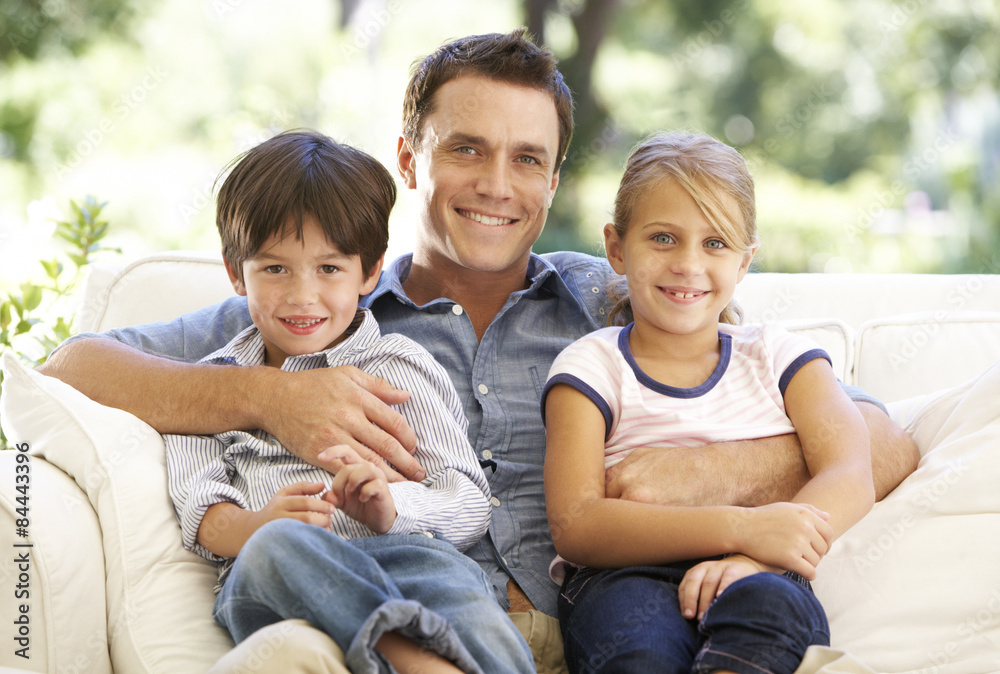 Father And Children Sitting On Sofa At Home Father And Children Sitting On Sofa At Home
