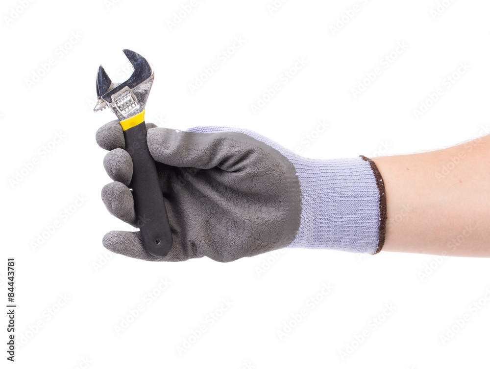 Hand in gloves holding adjustable wrench. Hand in gloves holding adjustable wrench.