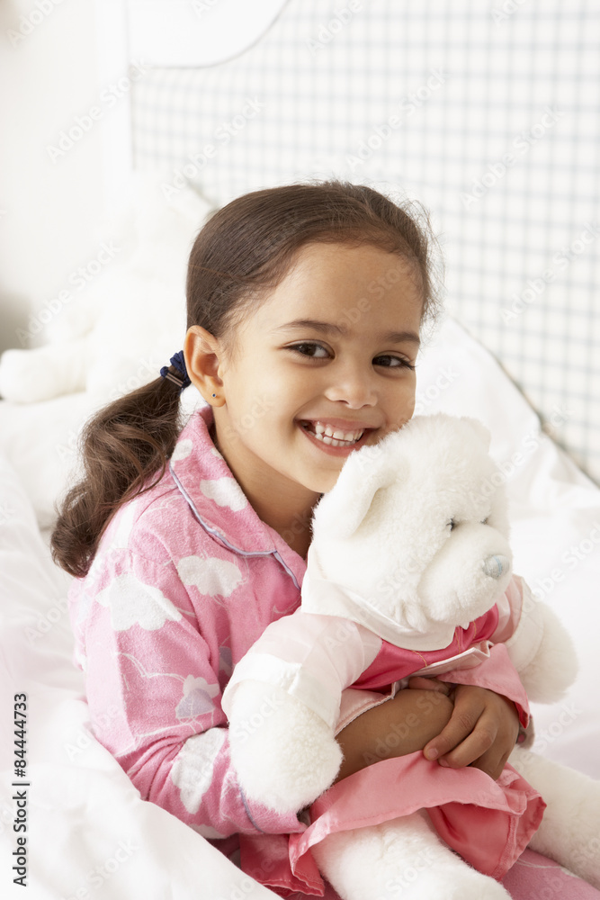 Young Girl Wearing Pajamas In Bed With Cuddly Toy Young Girl Wearing Pajamas In Bed With Cuddly Toy
