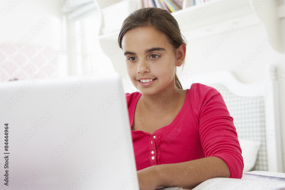 Girl Doing Homework At Desk In Bedroom Using Laptop Girl Doing Homework At Desk In Bedroom Using Laptop