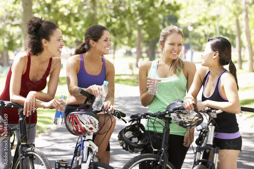 Group Of Women Resting During Cycle Ride Through Park