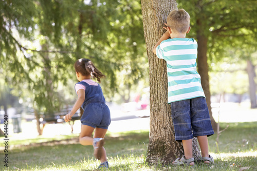 Two Children Playing Hide And Seek In Park photo