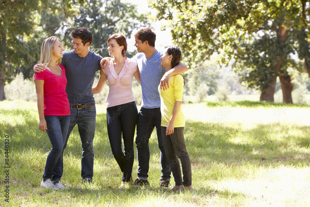 Group Of Young Friends Walking Through Countryside Group Of Young Friends Walking Through Countryside