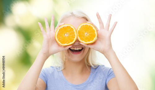 happy woman having fun covering eyes with orange