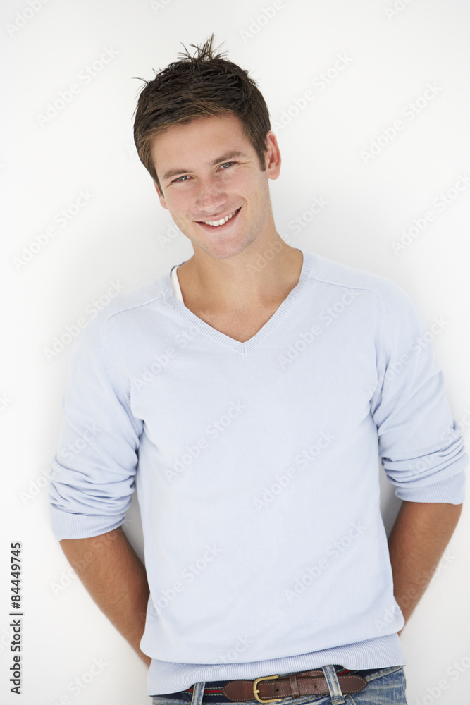 Studio Portrait Of Young Man Leaning Against White Background Studio Portrait Of Young Man Leaning Against White Background