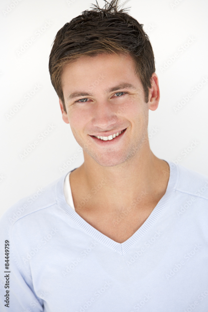 Studio Portrait Of Young Man Leaning Against White Background Studio Portrait Of Young Man Leaning Against White Background