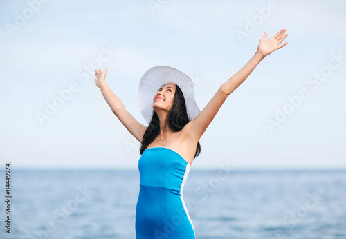 girl with hands up on the beach