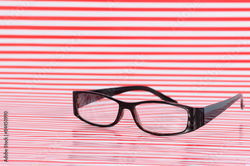 Brown eyeglasses on red texture line.