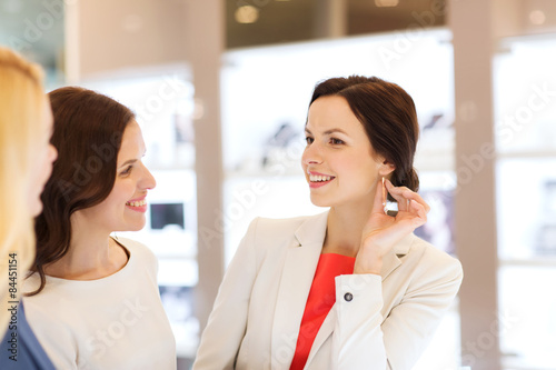 happy women choosing earrings at jewelry store