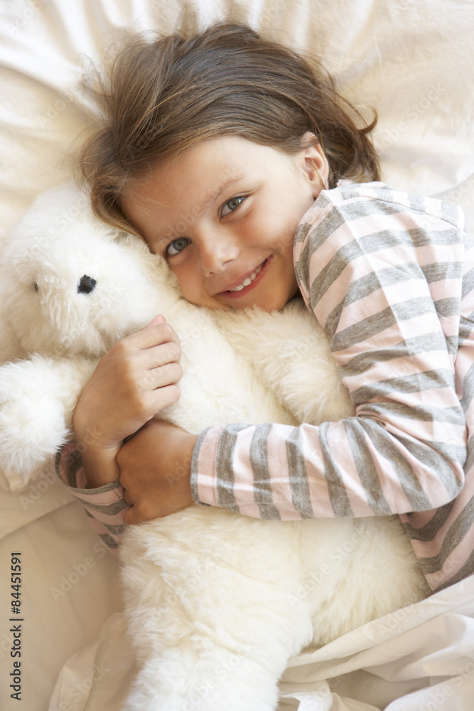 Young Girl Relaxing In Bed With Toy