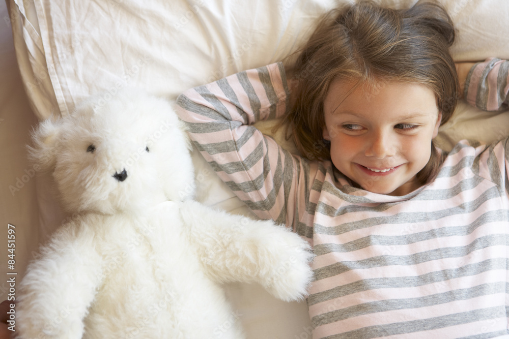 Young Girl Relaxing In Bed With Toy