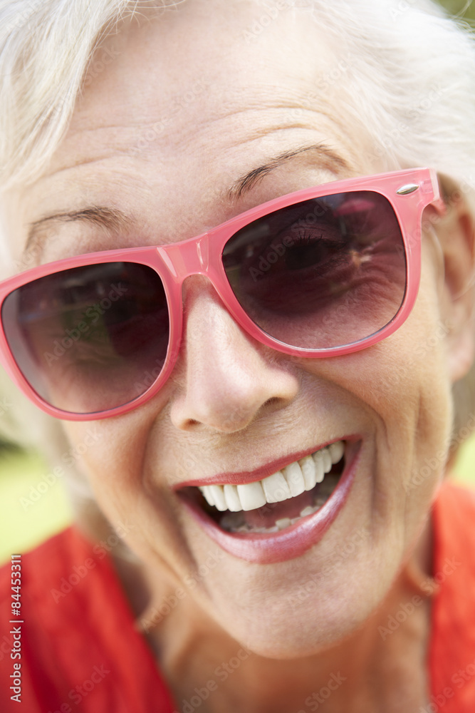 Head And Shoulders Portrait Of Smiling Senior Woman Wearing Sunglasses Head And Shoulders Portrait Of Smiling Senior Woman Wearing Sunglasses
