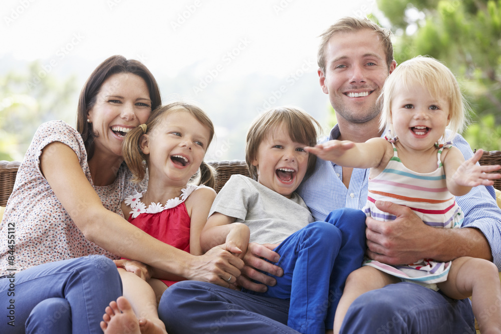 Family Sitting On Garden Seat Together Family Sitting On Garden Seat Together