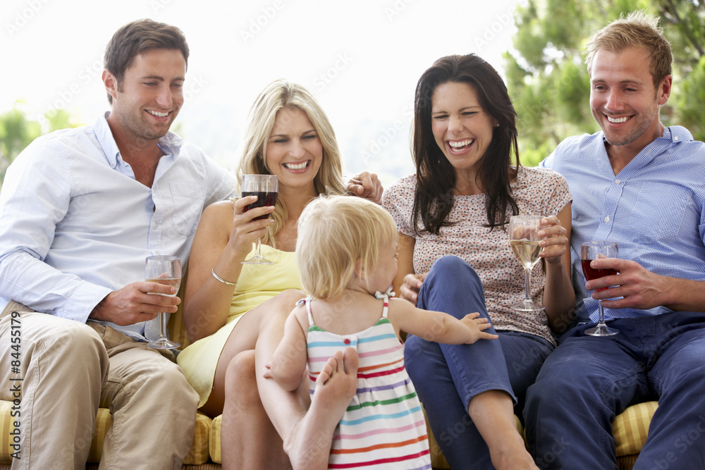 Group Of Friends Sitting On Outdoor Seat Together With Young Girl Group Of Friends Sitting On Outdoor Seat Together With Young Girl