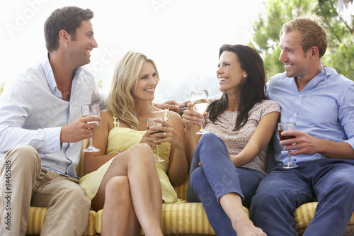 Group Of Friends Sitting On Outdoor Seat Together